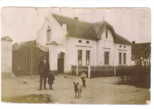 Period photograph of the family homestead in Radonice with the farmer, children and a dog